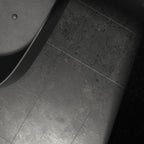 Close-up of Terrazerri Terrazzo Black 60cm x 60cm floor tiles, showcasing a deep charcoal finish with subtle terrazzo effect detailing and natural tonal variation beside a black freestanding bath.