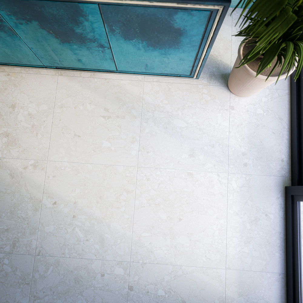 Terrazerri Terrazzo Ivory 60cm x 60cm floor tiles, showcasing a soft ivory base with subtle terrazzo effect detailing, paired with rich turquoise cabinetry for a fresh contrast.