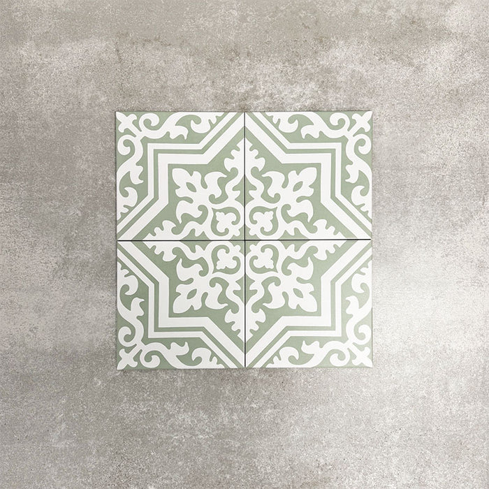 London Streets Thornton Place Sage Green 20cm x 20cm Victorian Moroccan style ceramic tiles arranged as four pieces to create a decorative star pattern, featuring intricate white detailing on a soft sage green background.