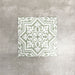 London Streets Thornton Place Sage Green 20cm x 20cm Victorian Moroccan style ceramic tiles arranged as four pieces to create a decorative star pattern, featuring intricate white detailing on a soft sage green background.
