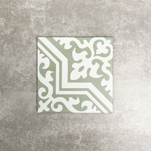 London Streets Thornton Place Sage Green 20cm x 20cm Victorian Moroccan style ceramic tile with intricate white ornamental pattern on a soft sage green background, shown as a single tile against a neutral textured backdrop.