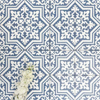 Overhead view of London Streets Thornton Place 20x20cm Victorian Moroccan style porcelain tiles arranged in a repeating blue and white patterned layout, styled with decorative foliage to highlight the intricate traditional Victorian-inspired floor design.