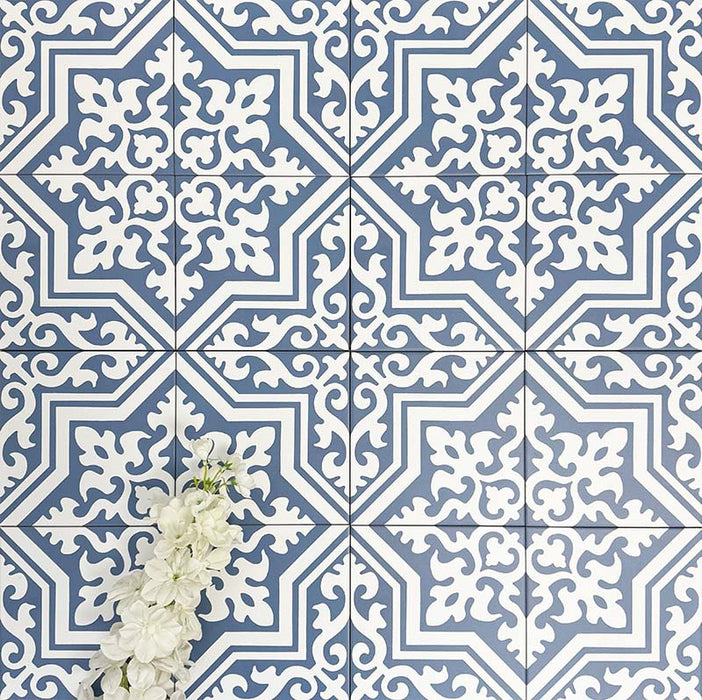 Overhead view of London Streets Thornton Place 20x20cm Victorian Moroccan style porcelain tiles arranged in a repeating blue and white patterned layout, styled with decorative foliage to highlight the intricate traditional Victorian-inspired floor design.