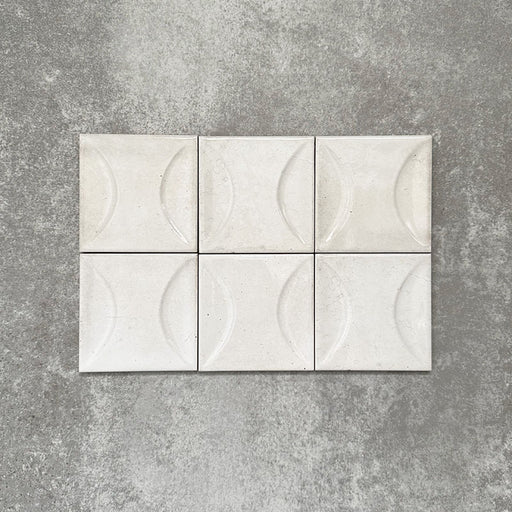 Close-up of Saigon White Decor Square Wall tiles, featuring Moroccan-style 10 × 10cm glossy ceramic tiles in soft white tones with a curved decorative relief pattern.