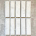Fayrouz White 5x20cm natural marble tiles with a honed finish, featuring a soft white base with subtle grey veining, arranged in a neat grid to highlight natural variation and tonal consistency.
