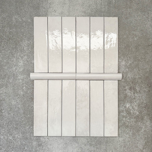 Nomad White bullnose pencil border ceramic tiles in a 3 × 20cm format, shown with matching brick tiles to highlight the coordinating white colour, gloss finish and rounded edge detail.