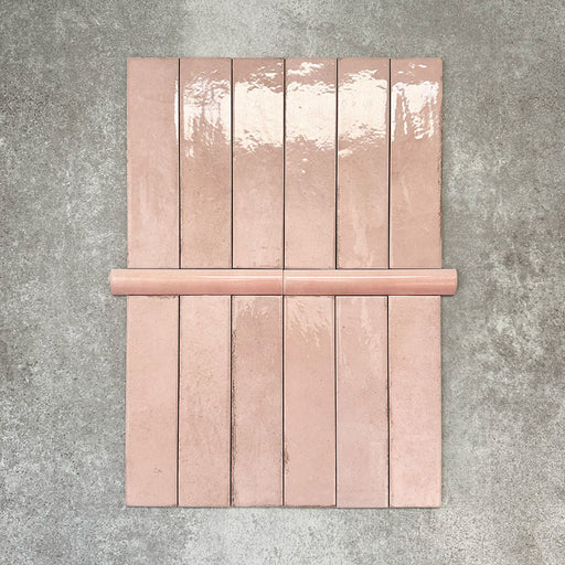 Nomad Rose bullnose pencil border ceramic tiles in a 3 × 20cm format, shown with matching brick tiles to highlight the soft pink colour, gloss finish and rounded edge detail.