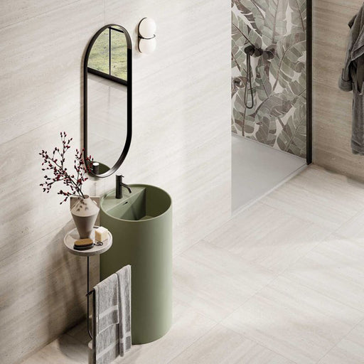 Contemporary bathroom featuring Trevi Stone matt porcelain wall and floor tiles in a soft stone effect finish, paired with a sage green basin, black brassware and a botanical feature wall for a calm, nature-inspired design.