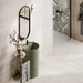 Contemporary bathroom featuring Trevi Stone matt porcelain wall and floor tiles in a soft stone effect finish, paired with a sage green basin, black brassware and a botanical feature wall for a calm, nature-inspired design.