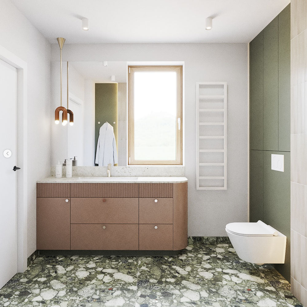 Modern bathroom featuring Venice Emerald matt terrazzo effect porcelain floor tiles with large marble chips, paired with blush vanity units, olive green cabinetry and warm neutral walls for a contemporary, luxurious interior.