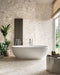 Luxury bathroom featuring Venice Ivory matt terrazzo effect porcelain tiles in a 60 x 120cm format across the walls and floor, creating a bright, seamless space with a freestanding bath and natural stone-inspired finish.