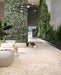 Spacious contemporary interior featuring Venice Ivory matt terrazzo effect porcelain tiles in a 60 x 120cm format, paired with a striking green terrazzo feature wall, indoor planting and modern minimalist furnishings.