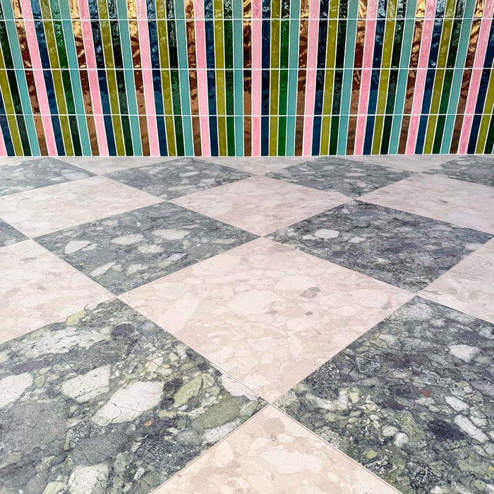 Venice Ivory and Venice Emerald matt terrazzo effect porcelain tiles laid in a striking chequerboard pattern, complemented by colourful gloss brick wall tiles for a bold, contemporary patio design.