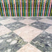 Venice Ivory and Venice Emerald matt terrazzo effect porcelain tiles laid in a striking chequerboard pattern, complemented by colourful gloss brick wall tiles for a bold, contemporary patio design.