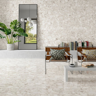 Contemporary living space featuring Venice Ivory polished terrazzo effect porcelain wall and floor tiles, showcasing soft ivory tones with natural stone chips, paired with modern furniture and greenery for a bright, elegant interior.