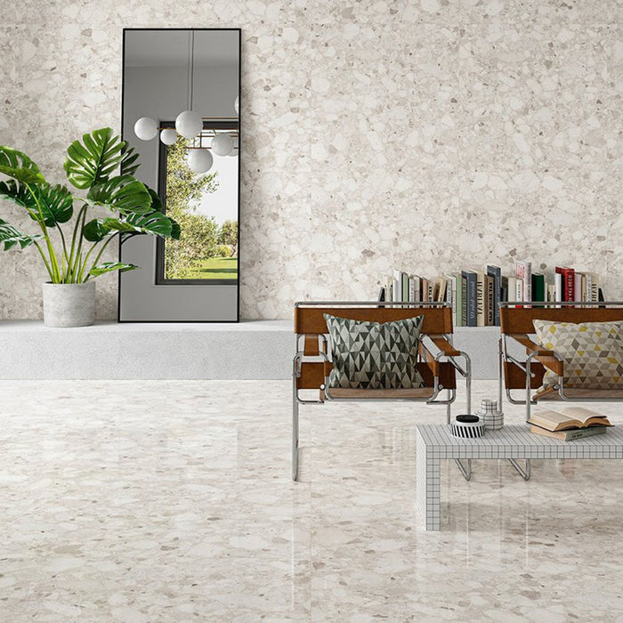 Contemporary living space featuring Venice Ivory polished terrazzo effect porcelain wall and floor tiles, showcasing soft ivory tones with natural stone chips, paired with modern furniture and greenery for a bright, elegant interior.
