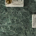 Bathroom interior featuring Verde Apia Polished Green Marble effect 60 × 60cm porcelain wall and floor tiles, styled with a floating vanity, brass basin, and rich green tones with intricate natural veining.
