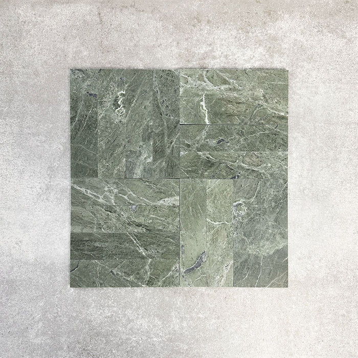 Arrangement featuring Fayrouz Verde 5x20cm natural marble tiles with a honed finish, laid in a basketweave-style pattern, showcasing rich green tones, varied veining and natural movement against a neutral background.