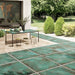 Outdoor patio featuring Verde Copper Oxide 2cm thick porcelain floor tiles in a metallic effect finish, styled with contemporary garden furniture, timber-effect steps, built-in planters and modern landscaping for a luxurious outdoor living space.