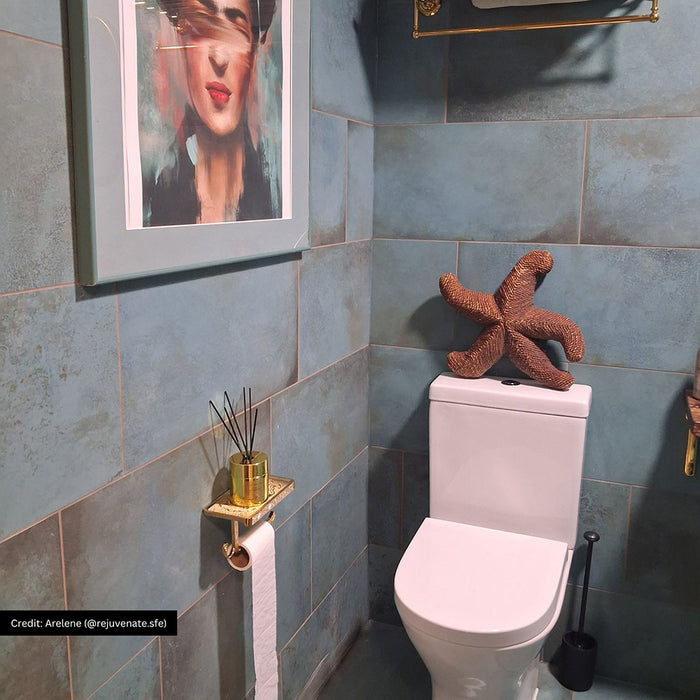 Bathroom featuring Verde Copper Oxide 30cm x 60cm metallic effect wall tiles, styled with brass shower fittings, a wall-mounted basin, wooden shelf and warm contemporary décor.