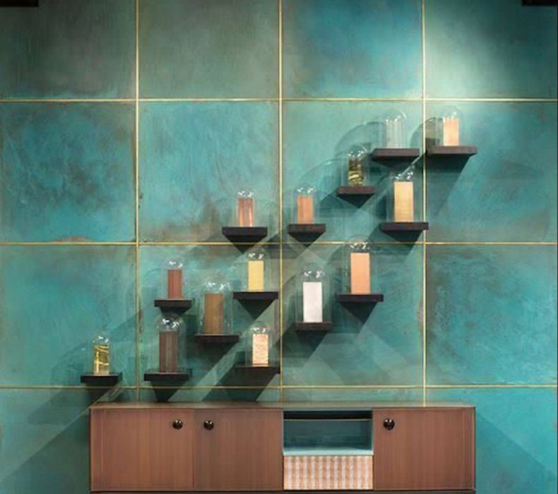 Contemporary interior featuring Verde Copper Oxide 60cm x 60cm metallic effect wall tiles, paired with timber cabinetry and minimalist shelving to create a striking industrial-inspired feature wall with rich blue-green tones.