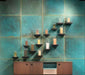 Contemporary interior featuring Verde Copper Oxide 60cm x 60cm metallic effect wall tiles, paired with timber cabinetry and minimalist shelving to create a striking industrial-inspired feature wall with rich blue-green tones.