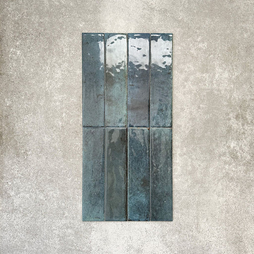 Allegra Blue Gloss Brick ceramic tiles in a 6 × 25cm format, shown laid vertically to highlight the deep blue tones, glossy finish and subtle handmade-style surface variation.