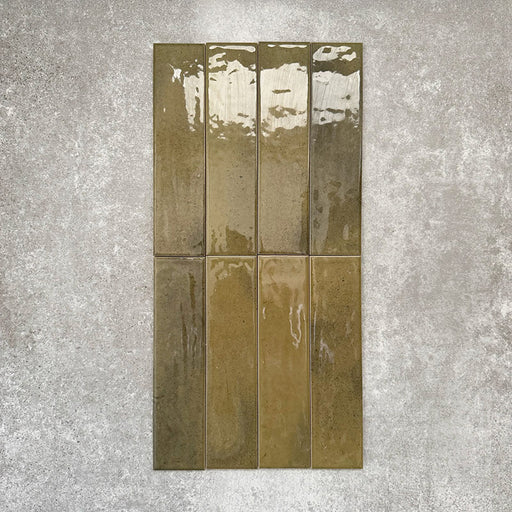 Allegra Daisy Green Gloss Brick ceramic tiles in a 6 × 25cm format, shown laid vertically to highlight the rich green tones, glossy finish and subtle handmade-style surface variation.