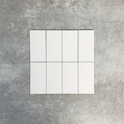 Close-up of Pimlico White 7.5 × 15cm ceramic tiles with a crackle glaze finish, showing soft white tones, subtle surface texture and a smooth rectangular format ideal for bathroom and kitchen walls.