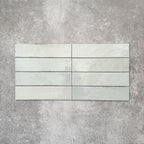 Nomad Mint Green brick wall tiles in a 6 × 24.6cm format, shown laid together to highlight the soft green colour, gloss finish and subtle surface variation.