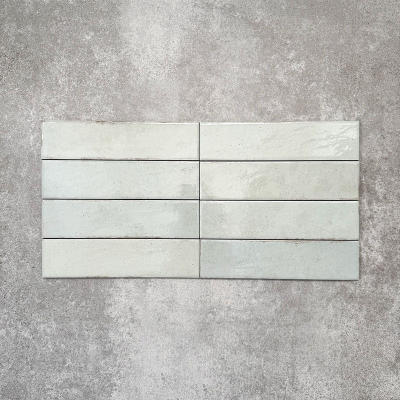 Nomad Mint Green brick wall tiles in a 6 × 24.6cm format, shown laid together to highlight the soft green colour, gloss finish and subtle surface variation.