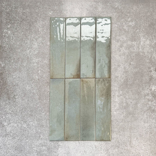 Allegra Celadon Green Gloss Brick ceramic tiles in a 6 × 25cm format, shown laid vertically to highlight the soft green tones, glossy finish and subtle handmade-style surface variation.