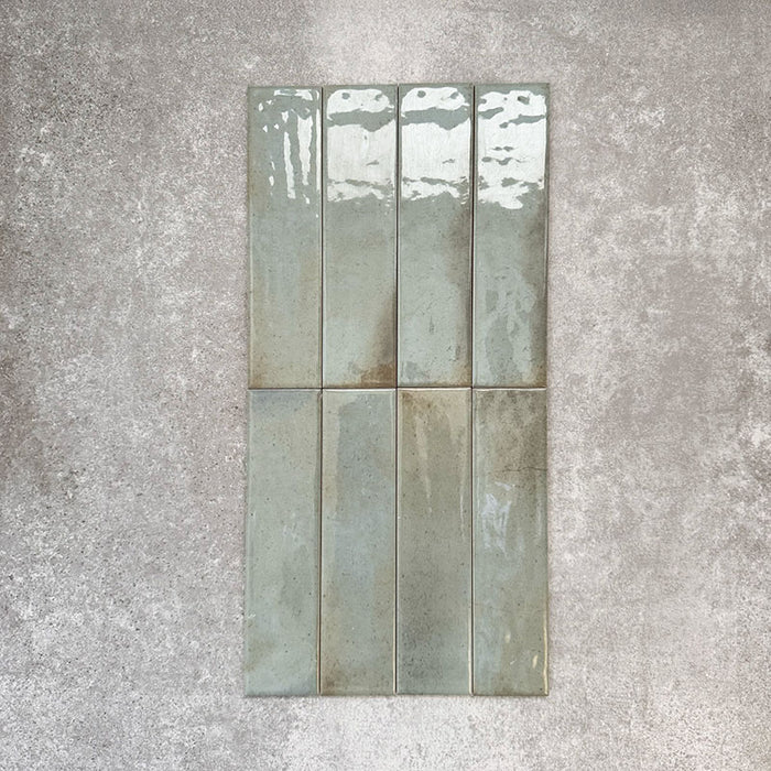 Allegra Celadon Green Gloss Brick ceramic tiles in a 6 × 25cm format, shown laid vertically to highlight the soft green tones, glossy finish and subtle handmade-style surface variation.