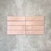 Nomad Rose brick wall tiles in a 6 × 24.6cm format, shown laid together to highlight the soft pink tone, gloss finish and subtle surface variation.