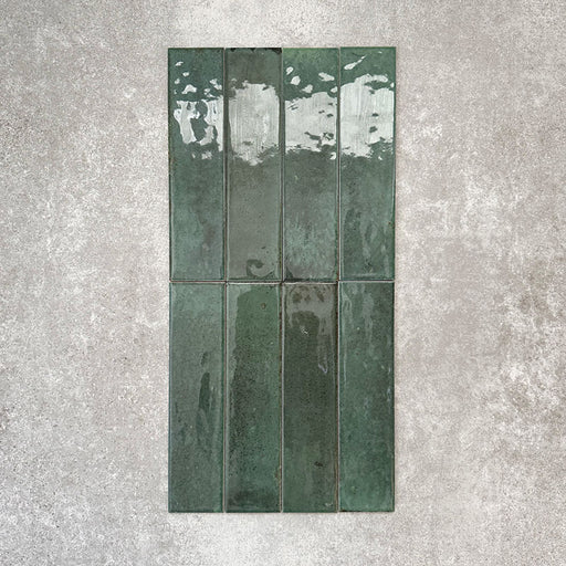 Allegra Green Gloss brick ceramic tiles in a 6 × 25cm format, shown in a vertical layout to highlight the glossy surface, deep green colour and natural tonal variation across each tile.