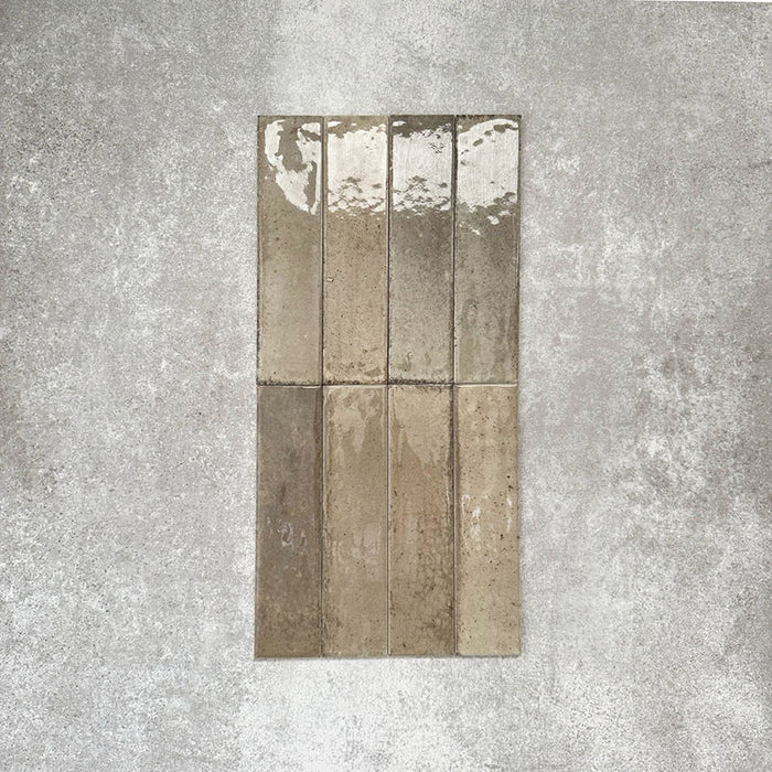 Allegra Sage Green Gloss Brick ceramic tiles in a 6 × 25cm format, shown laid vertically to highlight the muted green tones, glossy finish and subtle handmade-style surface variation.