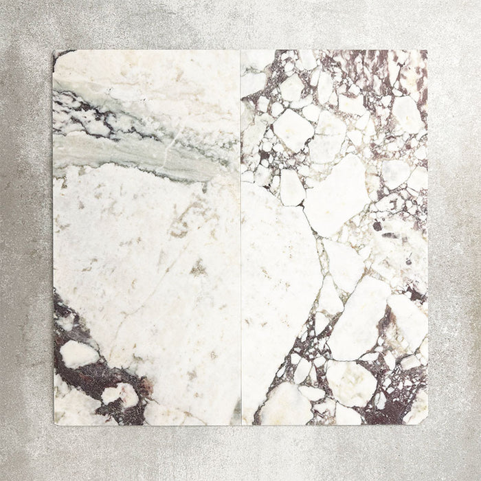 Close-up of Fayrouz Viola natural marble tiles in a honed finish, 30.5x61cm format, showcasing a soft white base with dramatic violet and deep grey veining, creating a bold yet refined look for wall and floor applications.