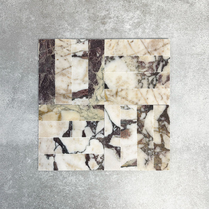 Arrangement featuring Fayrouz Viola 5x20cm natural marble tiles with a honed finish, laid in a basketweave pattern to create visual movement, showcasing a white base with bold burgundy and warm-toned veining and natural variation.