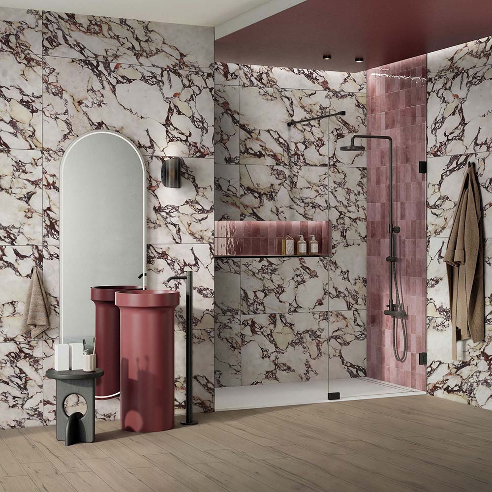 Bathroom interior featuring Viola Matt Honed Marble effect 60 × 120cm porcelain wall tiles, styled with a walk-in shower, burgundy vanity units, soft pink feature tiles, and bold veining creating a striking, design-led space.