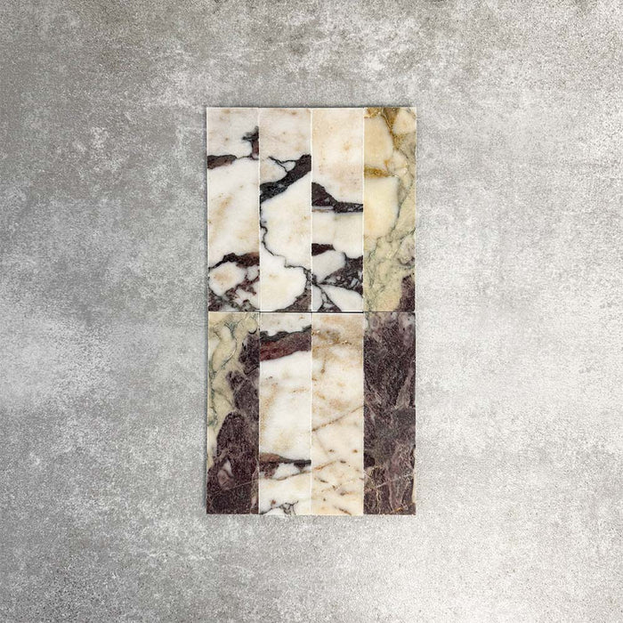 Fayrouz Viola 5x20cm natural marble tiles with a honed finish, featuring a white base with bold burgundy and warm-toned veining, arranged in a neat grid to highlight natural variation and distinctive stone detail.