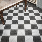 Vitoria Antique Black 30cm x 30cm marble effect chequerboard tiles, featuring a deep charcoal finish paired with white marble effect tiles to create a classic checkerboard floor, framed with a coordinating dark border.