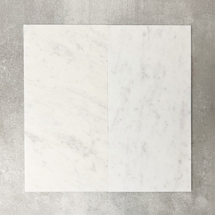 Close-up of Fayrouz White natural marble tiles in a honed finish, 30.5x61cm format, showcasing a soft white base with subtle grey veining and gentle tonal variation, creating a refined and timeless look for wall and floor applications.
