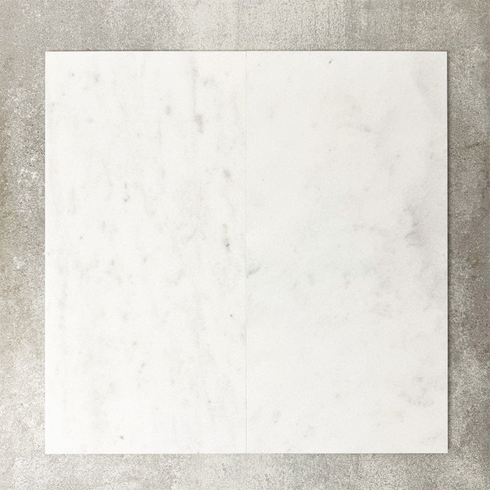 Close-up of Fayrouz White natural marble tiles in a honed finish, 30.5x61cm format, showcasing a soft white base with subtle grey veining and gentle tonal variation, creating a refined and timeless look for wall and floor applications.