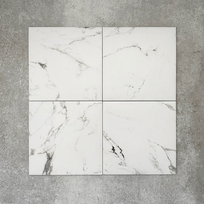 Four Florence Calacatta White 25x25cm marble-effect porcelain tiles displayed together, highlighting the subtle variation in grey veining and the clean, elegant white marble-look finish.