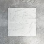 Arrangement featuring Fayrouz White 5x20cm natural marble tiles with a honed finish, laid in a basketweave pattern to create subtle movement, showcasing a soft white base with delicate grey veining and natural tonal variation.