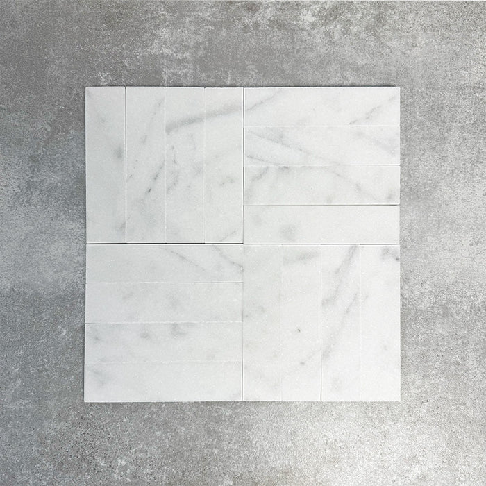 Arrangement featuring Fayrouz White 5x20cm natural marble tiles with a honed finish, laid in a basketweave pattern to create subtle movement, showcasing a soft white base with delicate grey veining and natural tonal variation.