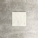 Single Fayrouz White 15.2x15.2cm natural marble tile with a honed finish, featuring soft white tones and subtle natural markings, displayed against a neutral textured background in a clean product setting.