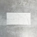 Fayrouz White 5x20cm natural marble tiles with a honed finish, featuring a soft white base with subtle grey veining, arranged in a neat grid to highlight natural variation and tonal consistency.