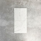 Fayrouz White 5x20cm natural marble tiles with a honed finish, featuring a soft white base with subtle grey veining, arranged in a neat grid to highlight natural variation and tonal consistency.
