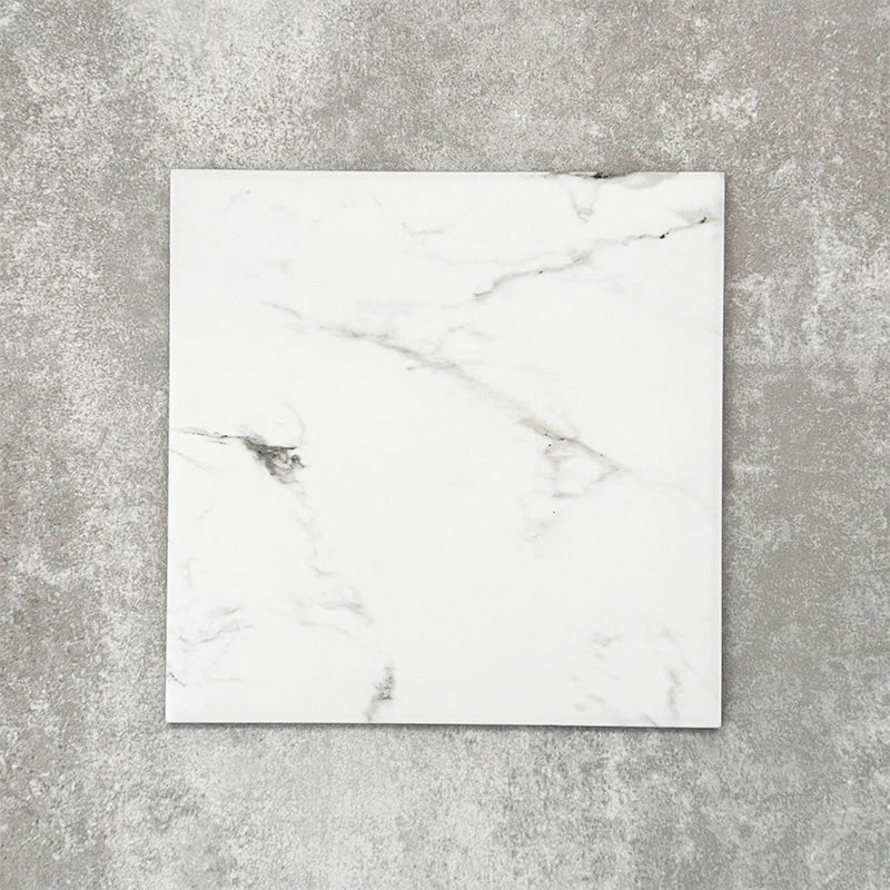 Close-up of Florence Calacatta White 25x25cm marble-effect porcelain tile, featuring a crisp white base with soft grey veining and a smooth, natural marble-look finish.
